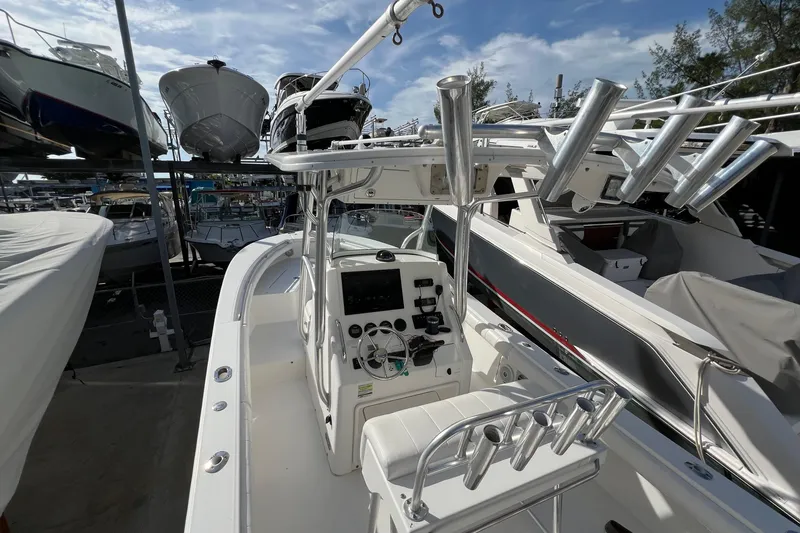 Slide: The Image of 2012 Regulator 24 Forward Seating boat with control panel, docked among other vessels. - 22