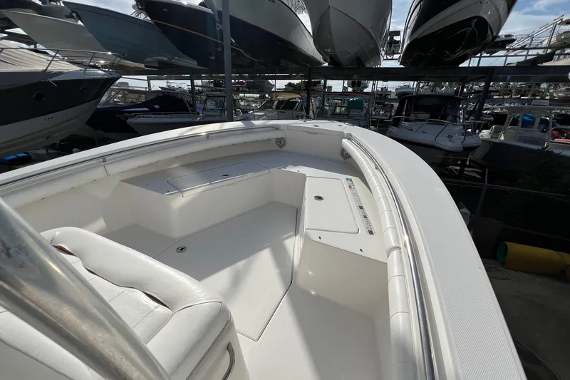 Slide: The Image of 2012 Regulator 24 Forward Seating boat in storage, showcasing spacious deck and seating area. - 25