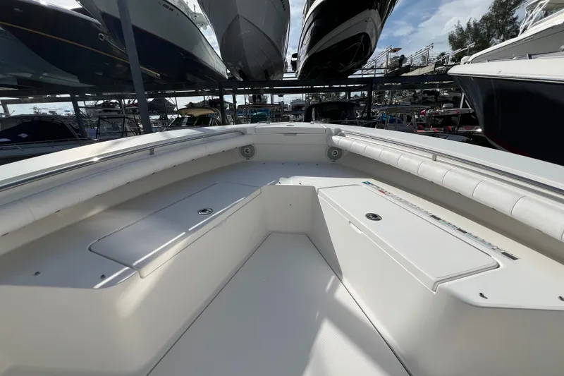 Slide: The Image of 2012 Regulator 24 Forward Seating boat interior with white cushioned seats and storage compartments. - 26