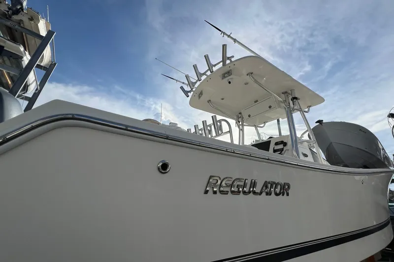 Slide: The Image of 2012 Regulator 24 Forward Seating boat with fishing rods, under a clear blue sky. - 3