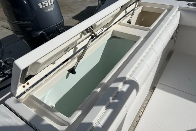Slide: The Image of 2012 Regulator 24 Forward Seating boat with open storage compartments and Yamaha 150 engines. - 32