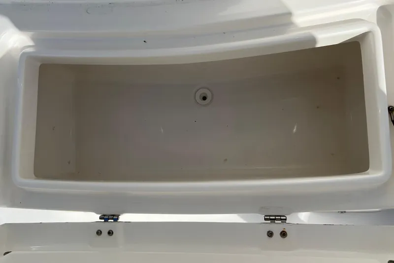 Slide: The Image of 2012 Regulator 24 Forward Seating storage compartment, open and empty, with white interior. - 34