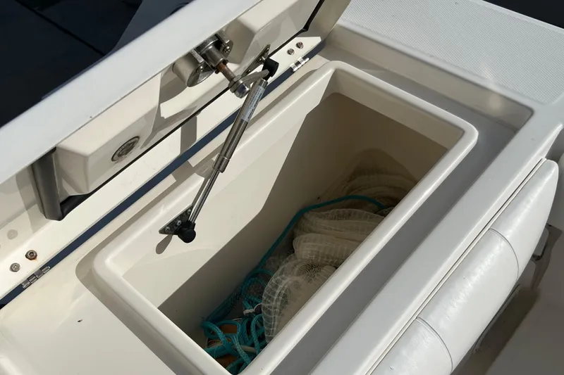 Slide: The Image of Open storage compartment on 2012 Regulator 24 Forward Seating boat, containing nets and ropes. - 35