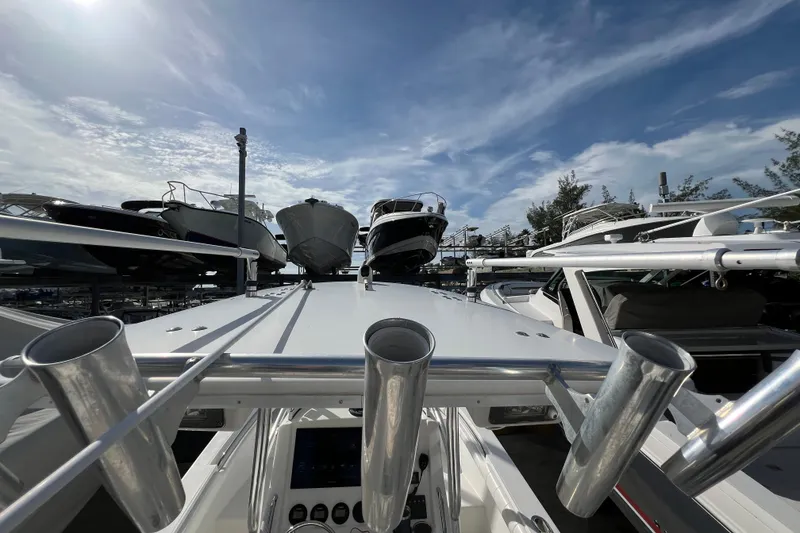 Slide: The Image of 2012 Regulator 24 Forward Seating boat with rod holders, docked under a clear blue sky. - 37