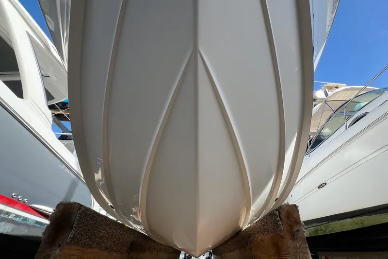 Slide: The Image of 2012 Regulator 24 Forward Seating boat hull on wooden supports, viewed from below. - 42