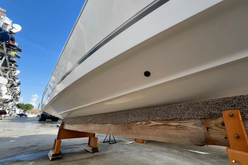 Slide: The Image of 2012 Regulator 24 Forward Seating boat on stand, viewed from below, clear blue sky. - 44