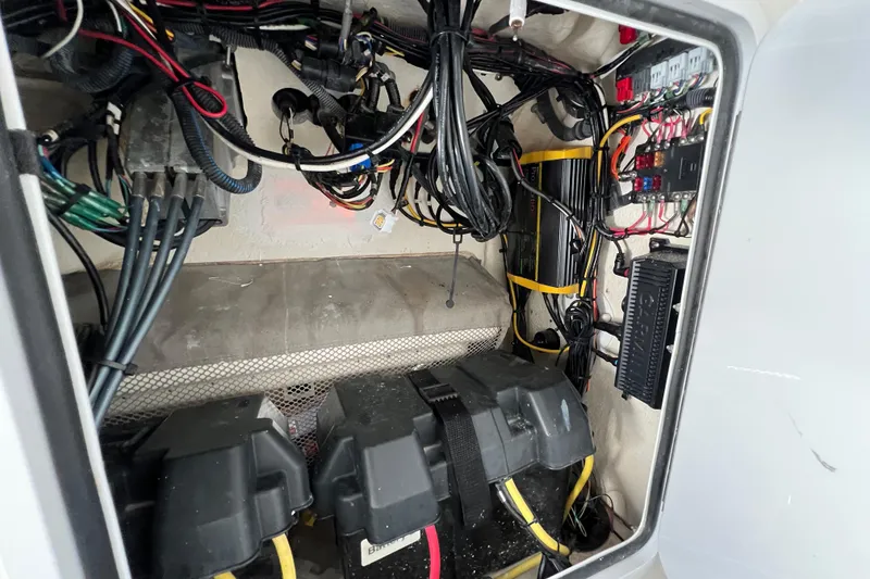 Slide: The Image of 2012 Regulator 24 Forward Seating boat electrical compartment with wiring and battery setup. - 48