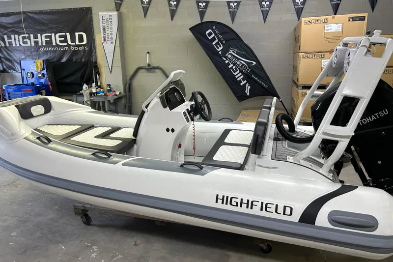 The Image of 2025 Highfield Sport 390 boat in showroom, featuring sleek design and Tohatsu engine. - 4
