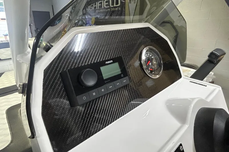 Slide: The Image of Dashboard of 2025 Highfield Sport 390 boat with carbon fiber finish and control panel. - 7