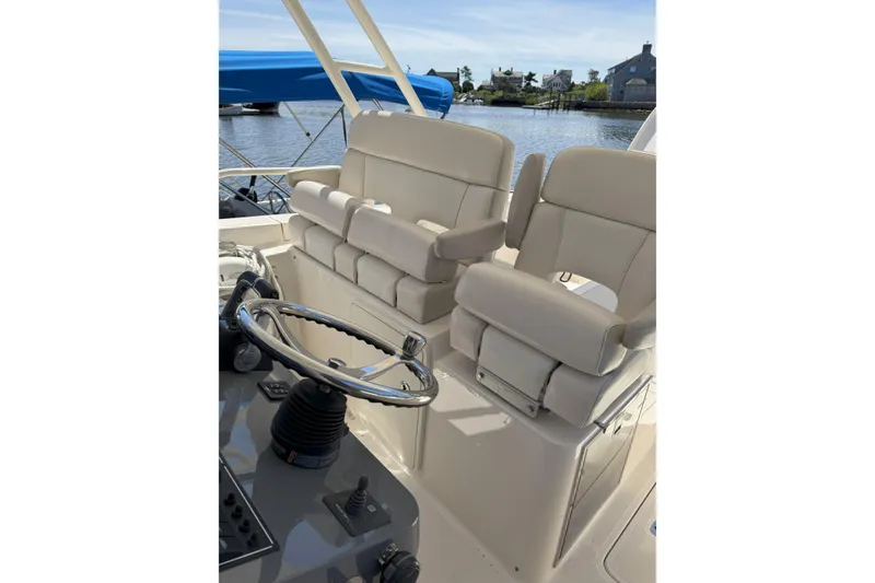 Slide: The Image of 2014 Pursuit ST 310 Sport boat interior with dual helm seats and steering wheel. - 12