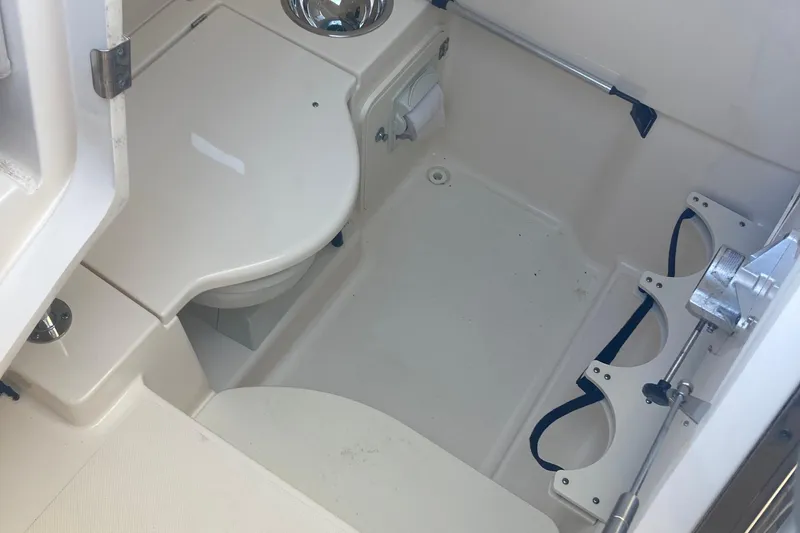 Slide: The Image of 2014 Pursuit ST 310 Sport boat interior with compact bathroom amenities. - 15