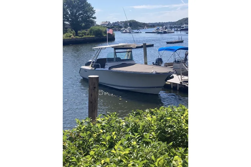 Slide: The Image of 2014 Pursuit ST 310 Sport boat docked in a scenic marina setting. - 3