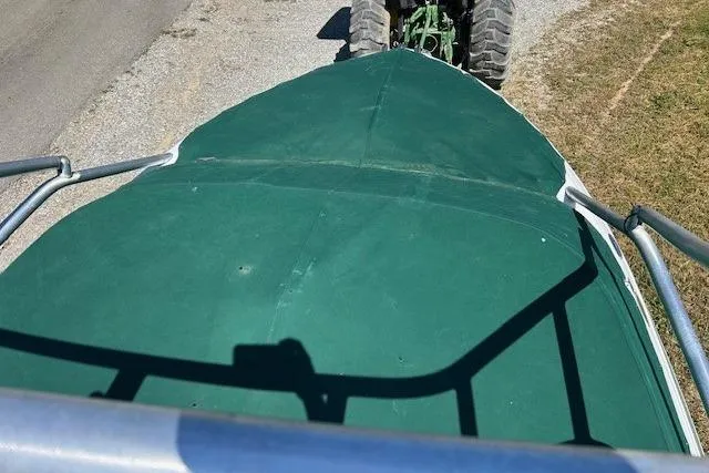 Slide: The Image of 2006 Four Winns H210 boat with green cover, viewed from above, on a trailer. - 24
