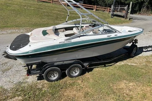 Slide: The Image of 2006 Four Winns H210 boat on trailer, parked on grass. - 4