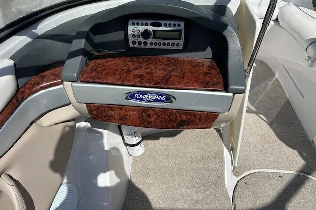 Slide: The Image of 2006 Four Winns H210 boat dashboard with wood paneling and stereo system. - 6