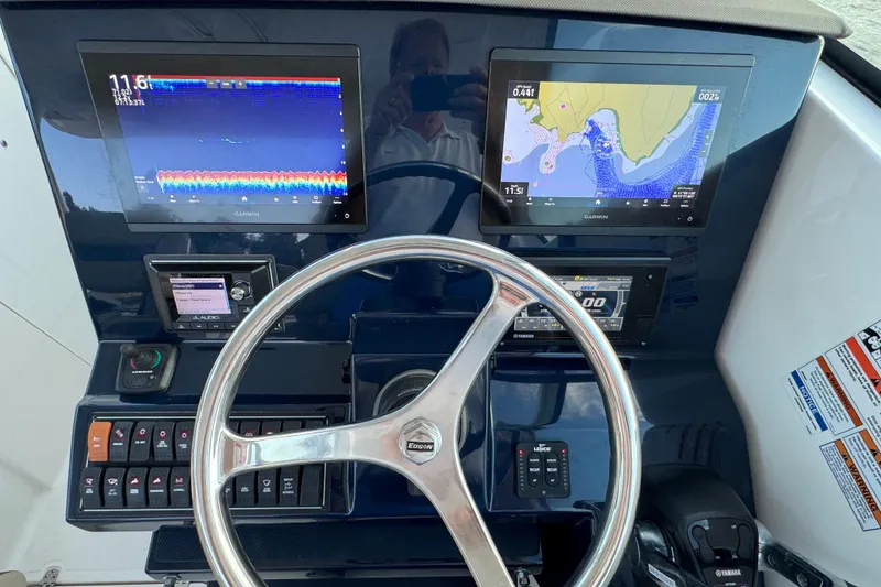 Slide: The Image of 2021 Pursuit DC 326 Dual Console helm with Garmin displays and steering wheel. - 13