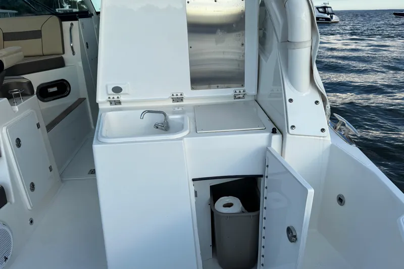 Slide: The Image of 2021 Pursuit DC 326 Dual Console boat interior with sink and storage. - 14