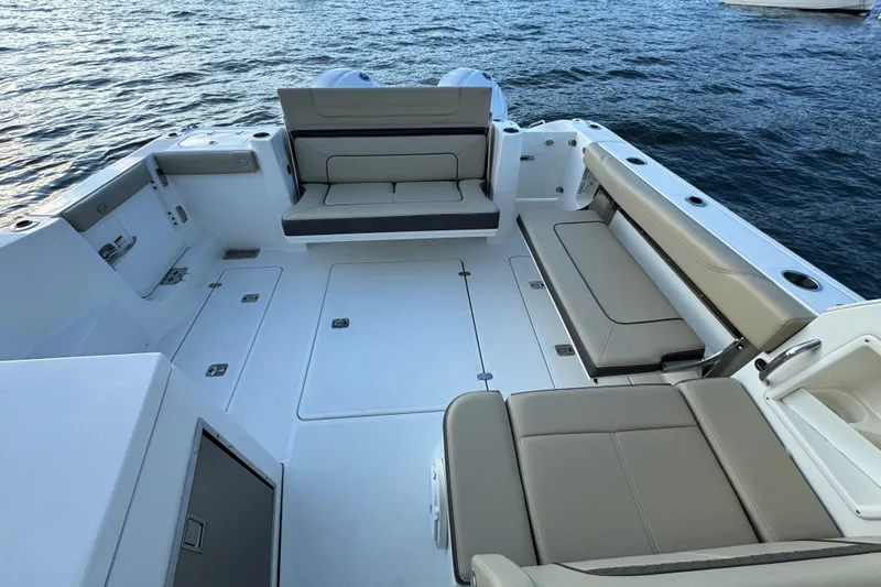 Slide: The Image of 2021 Pursuit DC 326 Dual Console boat interior with spacious seating and ocean backdrop. - 15