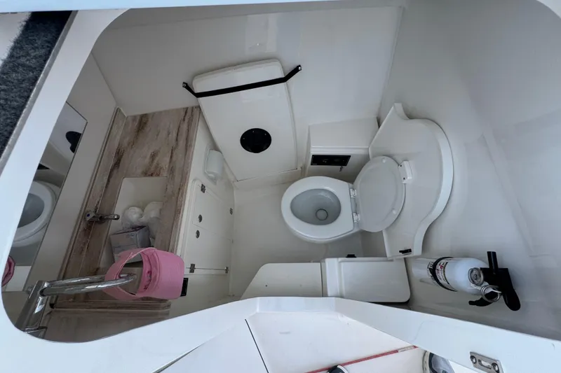 Slide: The Image of 2021 Pursuit DC 326 Dual Console boat bathroom with toilet, sink, and storage. - 22