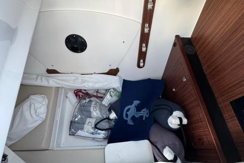 Slide: The Image of Interior cabin of 2021 Pursuit DC 326 Dual Console boat with storage and bedding. - 24