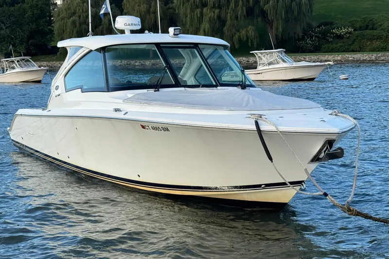 Slide: The Image of 2021 Pursuit DC 326 Dual Console boat anchored on calm water. - 3