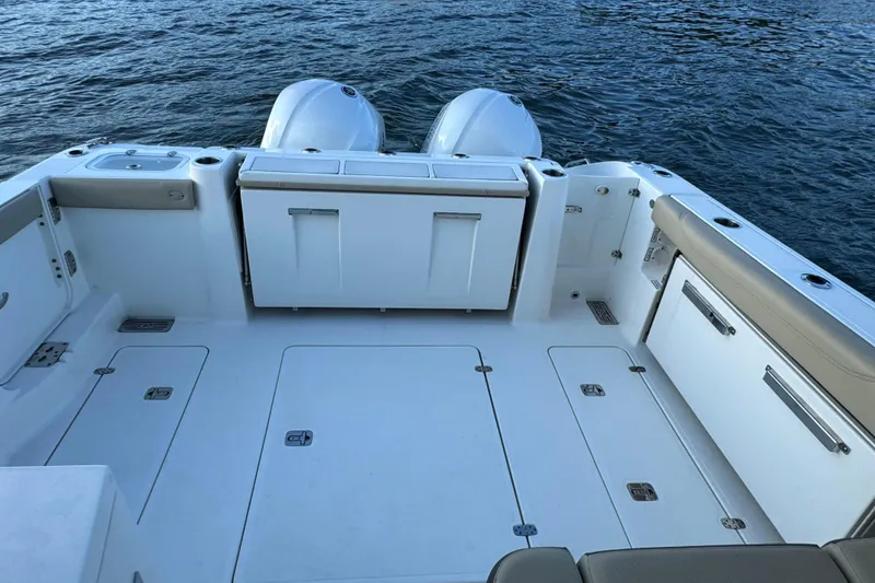 Slide: The Image of 2021 Pursuit DC 326 Dual Console boat deck with twin engines on water. - 8