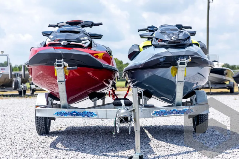 Slide: The Image of 2024 Sea-Doo RXP-X 325 jet skis on trailer, red and gray models, parked outdoors. - 2