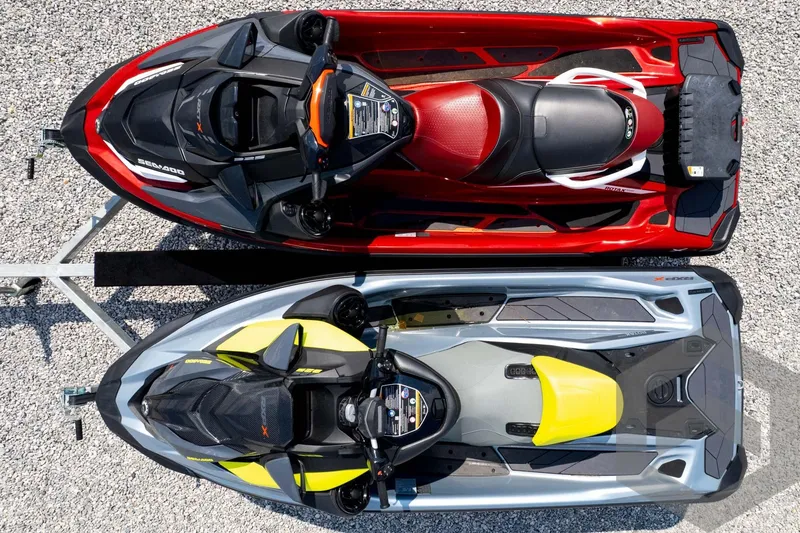 Slide: The Image of Top view of 2024 Sea-Doo RXP-X 325 jet skis in red and gray on gravel. - 48