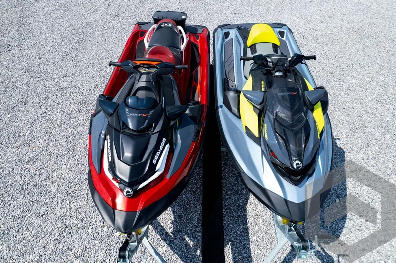 Slide: The Image of 2024 Sea-Doo RXP-X 325 jet skis in red and yellow on gravel surface. - 53