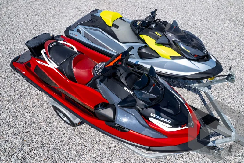 Slide: The Image of 2024 Sea-Doo RXP-X 325 jet skis in red and silver on a gravel surface. - 54