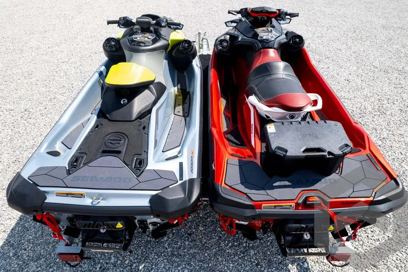 Slide: The Image of 2024 Sea-Doo RXP-X 325 jet skis, silver and red, parked on gravel. - 57