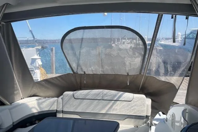 Slide: The Image of 2014 Formula 370 Super Sport boat interior with seating and clear canopy, docked by the water. - 10