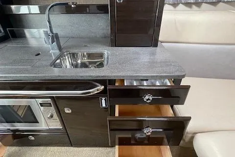 Slide: The Image of 2014 Formula 370 Super Sport interior kitchen with sink, microwave, and open drawers. - 30