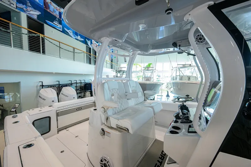 Slide: The Image of 2026 Sportsman Open 322 Center Console boat interior in showroom, featuring modern seating and controls. - 21