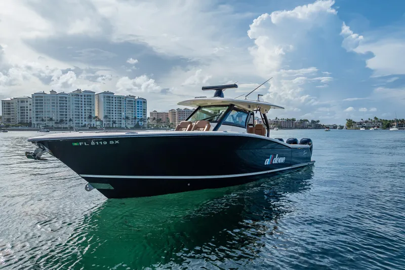 The Image of 2021 Scout 380 LXF boat on water with cityscape background. - 0