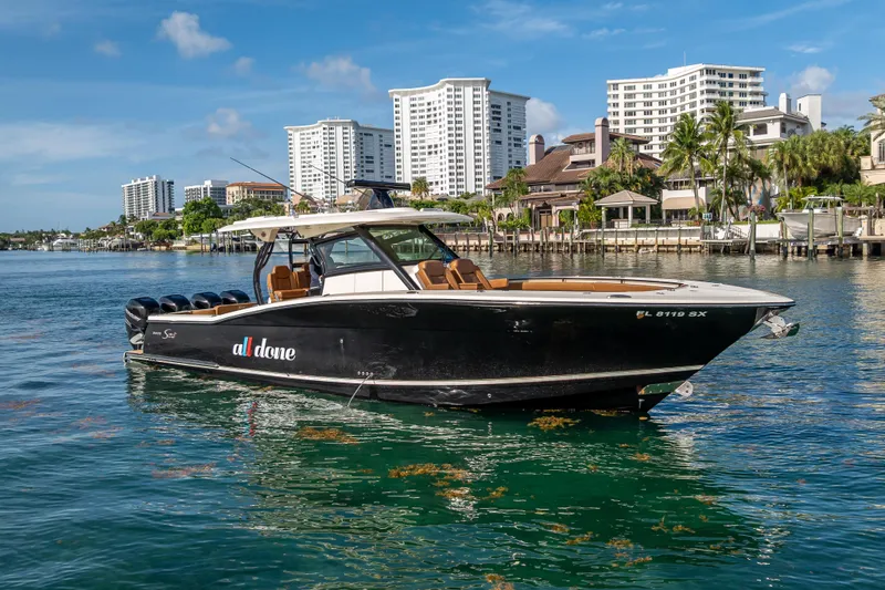 Slide: The Image of 2021 Scout 380 LXF boat on water with cityscape background. - 11