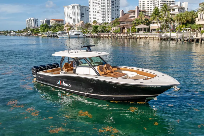 Slide: The Image of 2021 Scout 380 LXF boat on water, city skyline in background. - 18