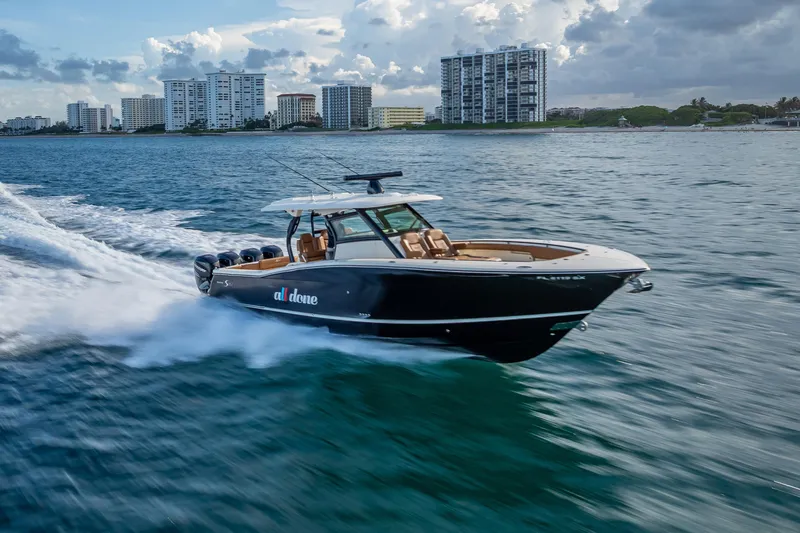 Slide: The Image of 2021 Scout 380 LXF boat cruising on ocean near city skyline. - 23