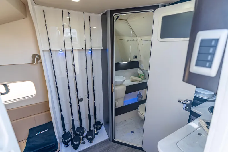 Slide: The Image of Interior of 2021 Scout 380 LXF boat featuring fishing rods and modern bathroom amenities. - 33