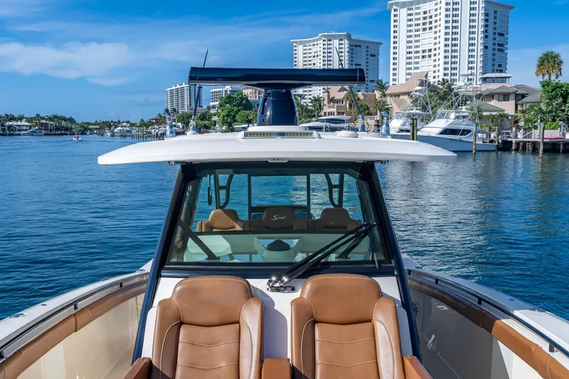Slide: The Image of 2021 Scout 380 LXF boat on water, city skyline in background. - 38