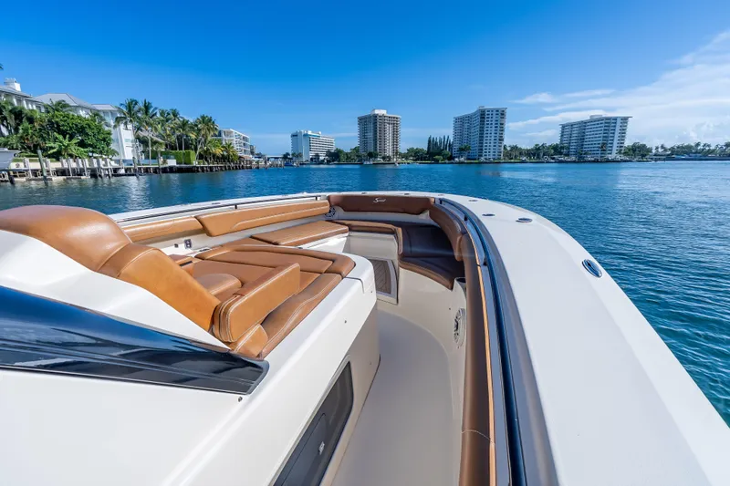 Slide: The Image of 2021 Scout 380 LXF boat with luxurious seating on a sunny waterfront. - 42