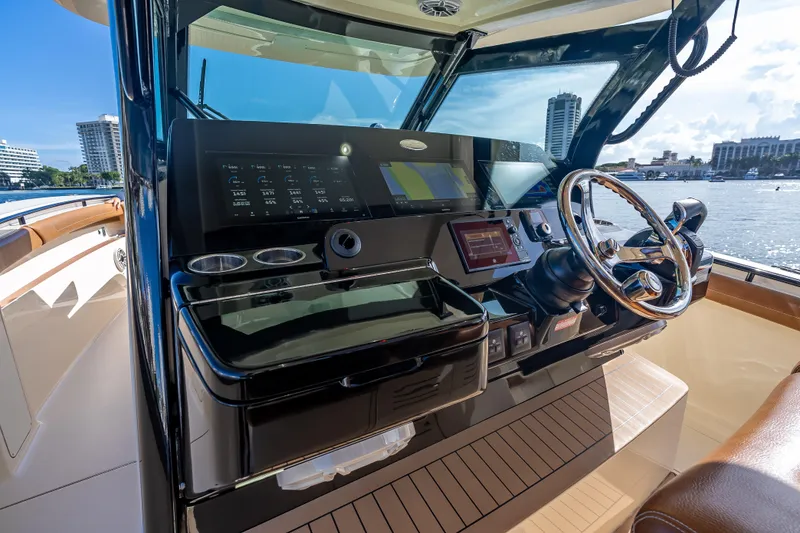 Slide: The Image of 2021 Scout 380 LXF boat helm with modern controls and waterfront view. - 49