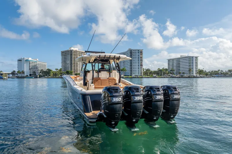 Slide: The Image of 2021 Scout 380 LXF boat with four engines on water, cityscape background. - 8