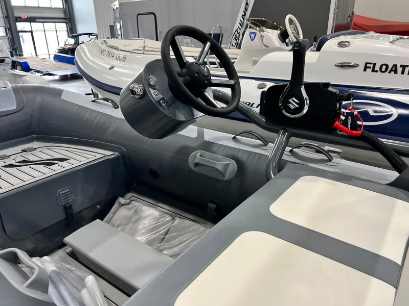 Slide: The Image of 2023 Highfield Classic 310 FCT inflatable boat interior with steering console and seating. - 2