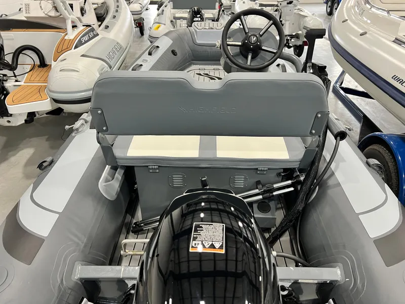 Slide: The Image of 2023 Highfield Classic 310 FCT inflatable boat interior with steering console and outboard motor. - 6