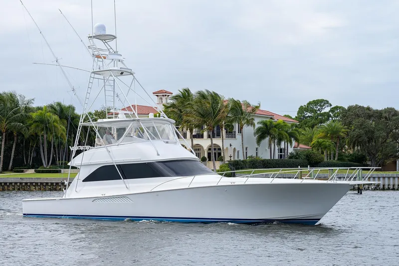 The Image of 2005 Viking 61 yacht cruising near waterfront mansion with palm trees. - 1