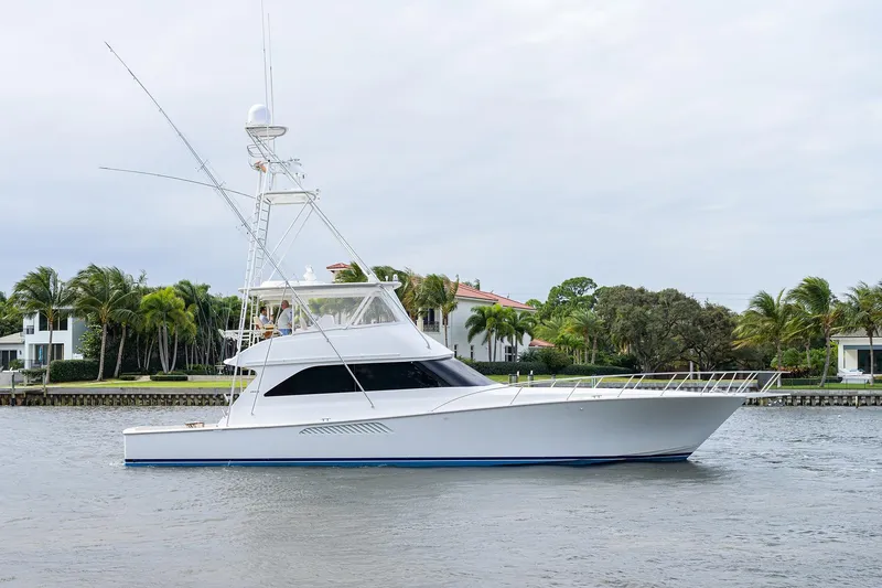 Slide: The Image of 2005 Viking 61 yacht cruising near waterfront homes with palm trees. - 10