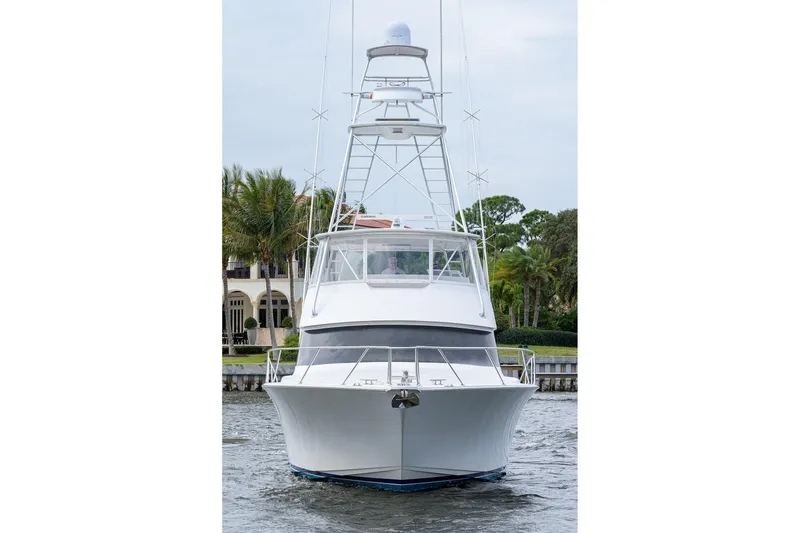 Slide: The Image of 2005 Viking 61 yacht on water, front view with lush greenery background. - 101