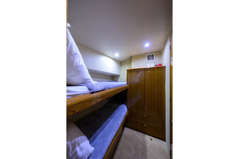 Slide: The Image of Interior of 2005 Viking 61 yacht with cozy bunk beds and wooden cabinetry. - 12