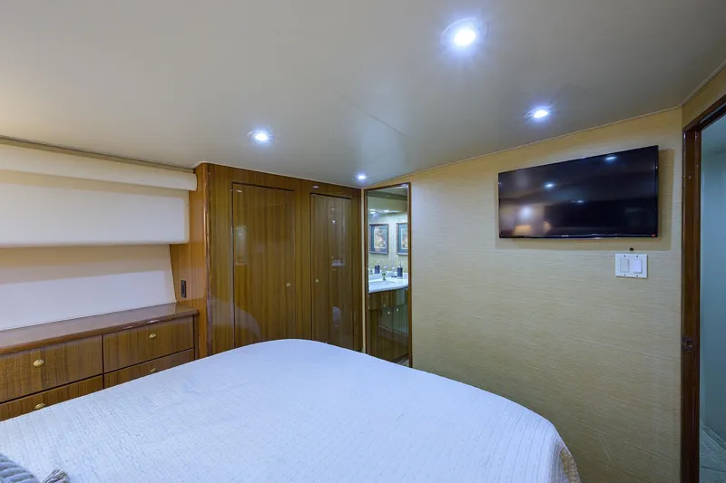 Slide: The Image of Luxurious bedroom interior of 2005 Viking 61 yacht with TV and wooden cabinetry. - 20